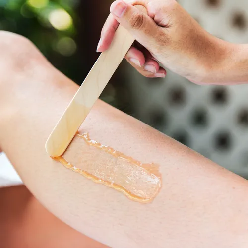 Épilation jambes entières à la cire résultat peau lisse.