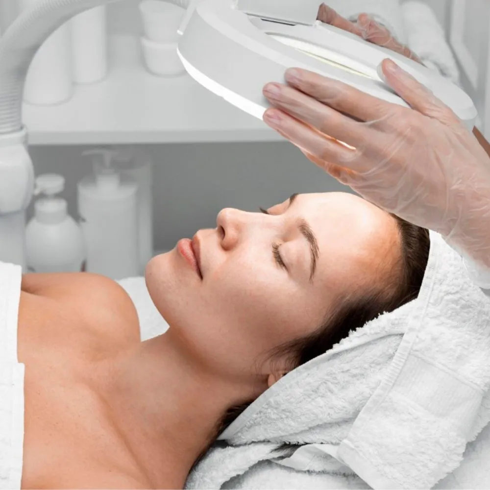 Esthéticienne examine peau lampe loupe traitement anti-imperfections